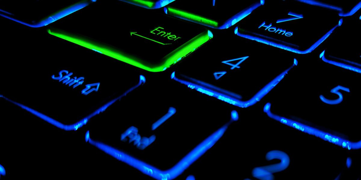 A close-up view of a backlit keyboard with glowing keys offers the keys to podcast success. The Enter key glows green, while Shift, Home, End, and number keys shine in blue, crafting a vibrant contrast against the dark background.