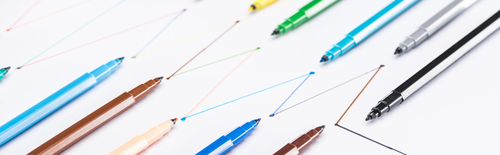 A row of colorful marker pens draws zigzag lines on white paper, arranged diagonally from the bottom left to the top right of the image, evoking a sense of creativity and podcast motivation. Podcasting is never a straight line.